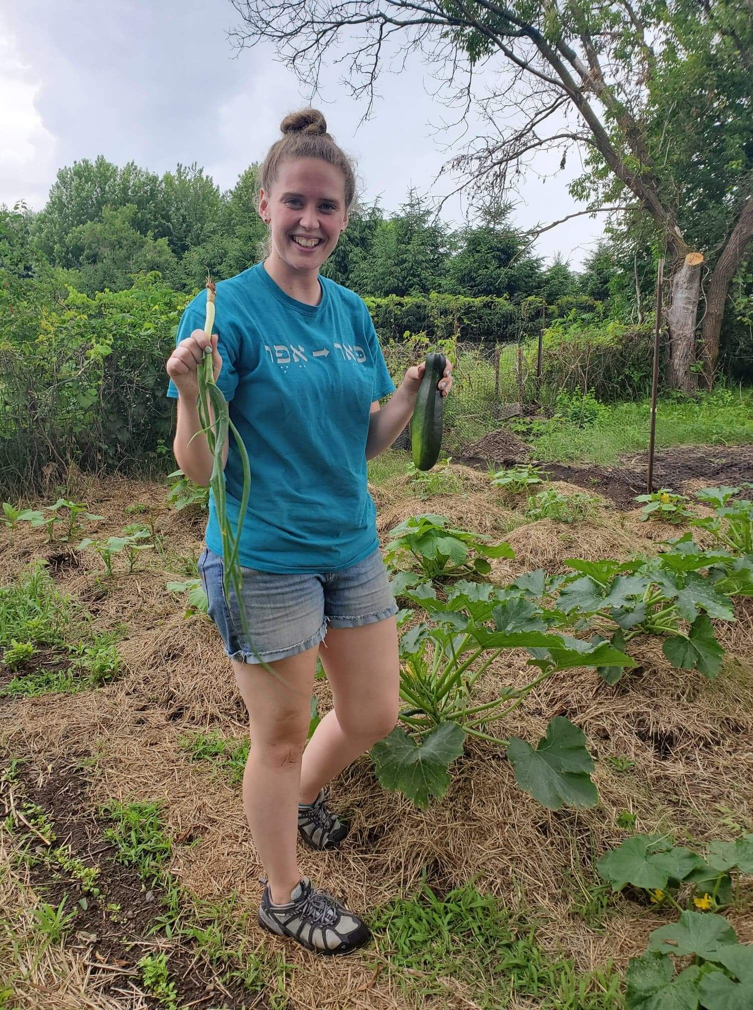 A smiling young woman holding a fresh harvest in the farm garden